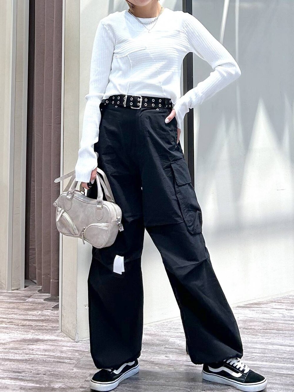 ホワイト系のニット/セーター、ブラック系のカーゴパンツ、ベージュ系のボストンバッグを着用したレディースの春コーディネートの4枚目の写真