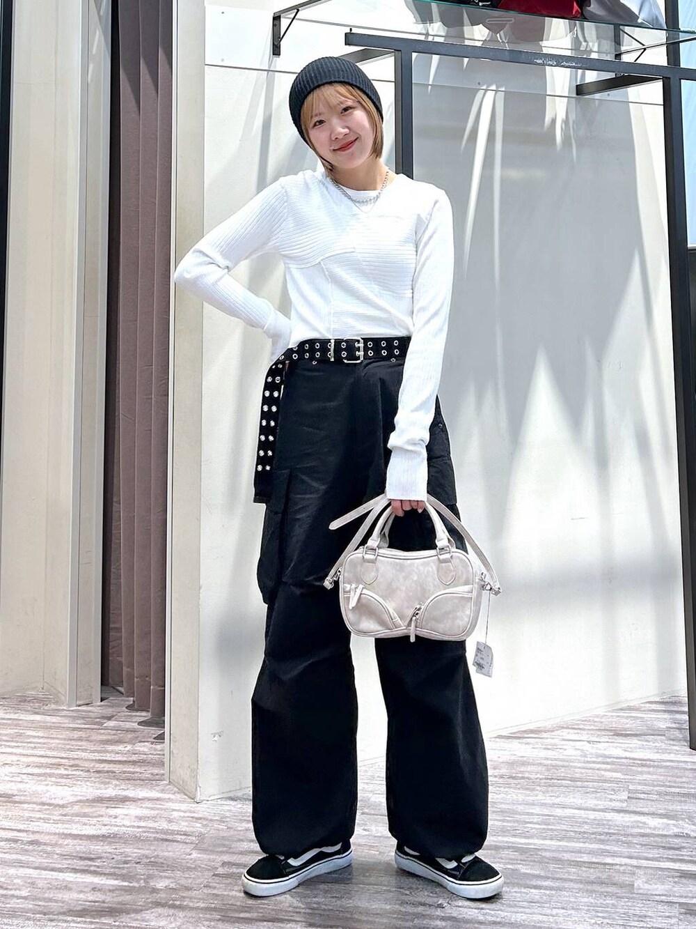 ホワイト系のニット/セーター、ブラック系のカーゴパンツ、ベージュ系のボストンバッグを着用したレディースの春コーディネートの7枚目の写真