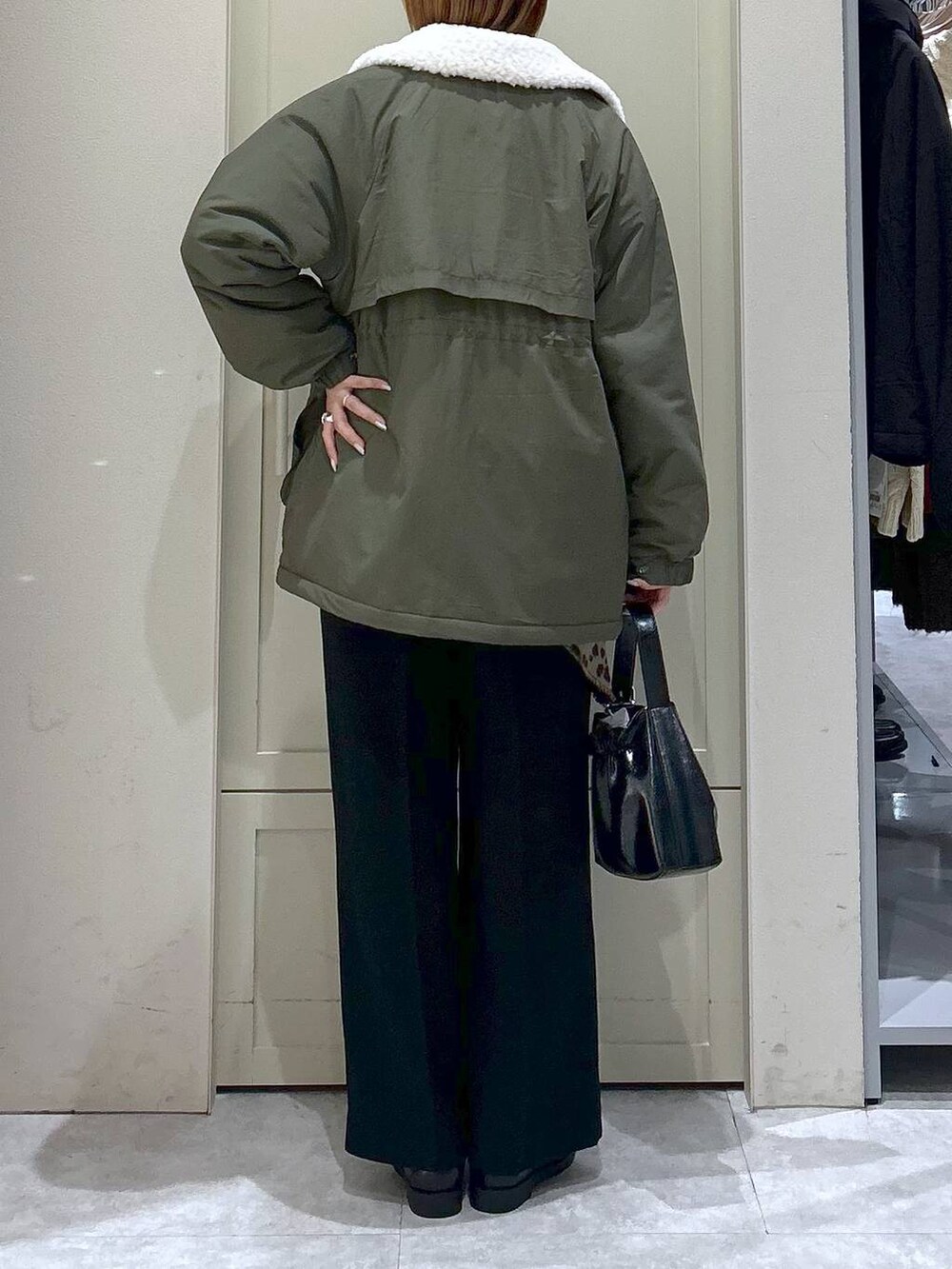 ブラック系のスラックス、グリーン系のその他アウター、ブラック系のローファーを着用したレディースの冬コーディネートの6枚目の写真