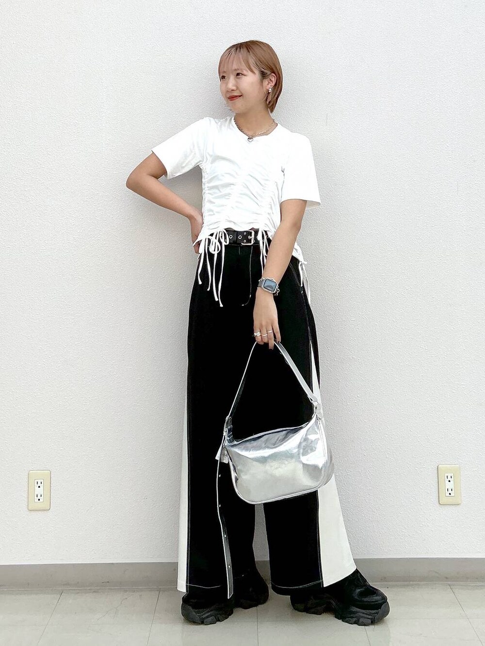 ブラック系のスニーカー、シルバー系のショルダーバッグ、ホワイト系のTシャツ/カットソーを着用したレディースの夏コーディネートの7枚目の写真