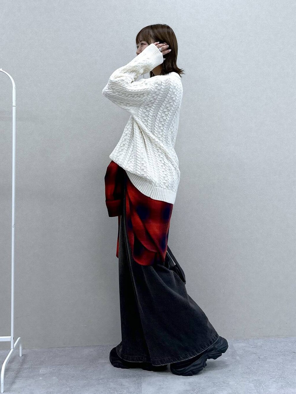 ブラック系のスニーカー、ブラック系のデニムパンツ、ブラック系のショルダーバッグを着用したレディースの冬コーディネートの2枚目の写真