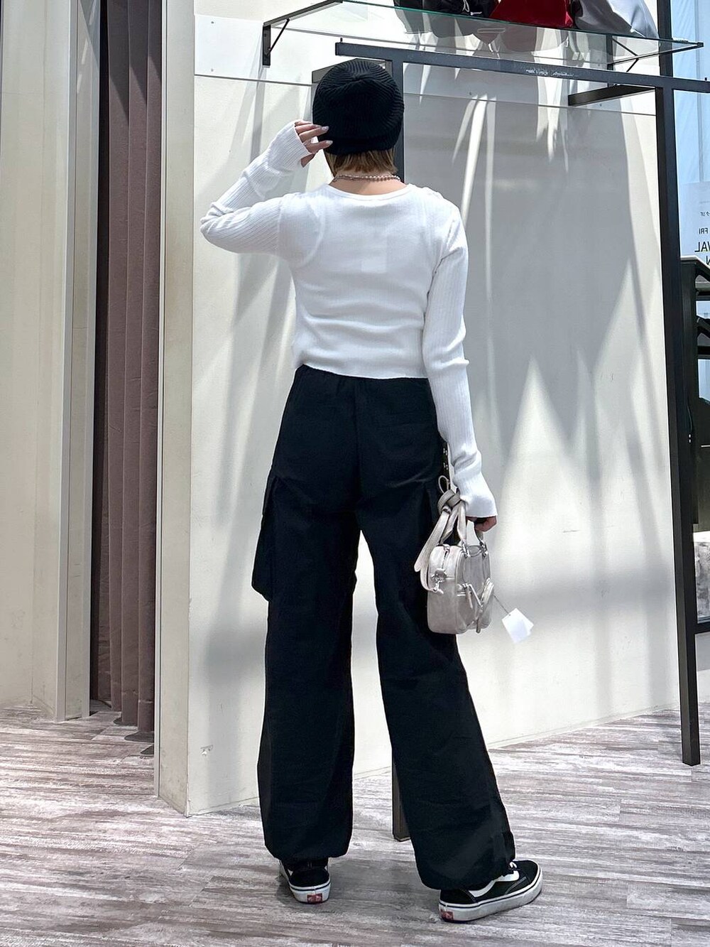 ホワイト系のニット/セーター、ブラック系のカーゴパンツ、ベージュ系のボストンバッグを着用したレディースの春コーディネートの3枚目の写真