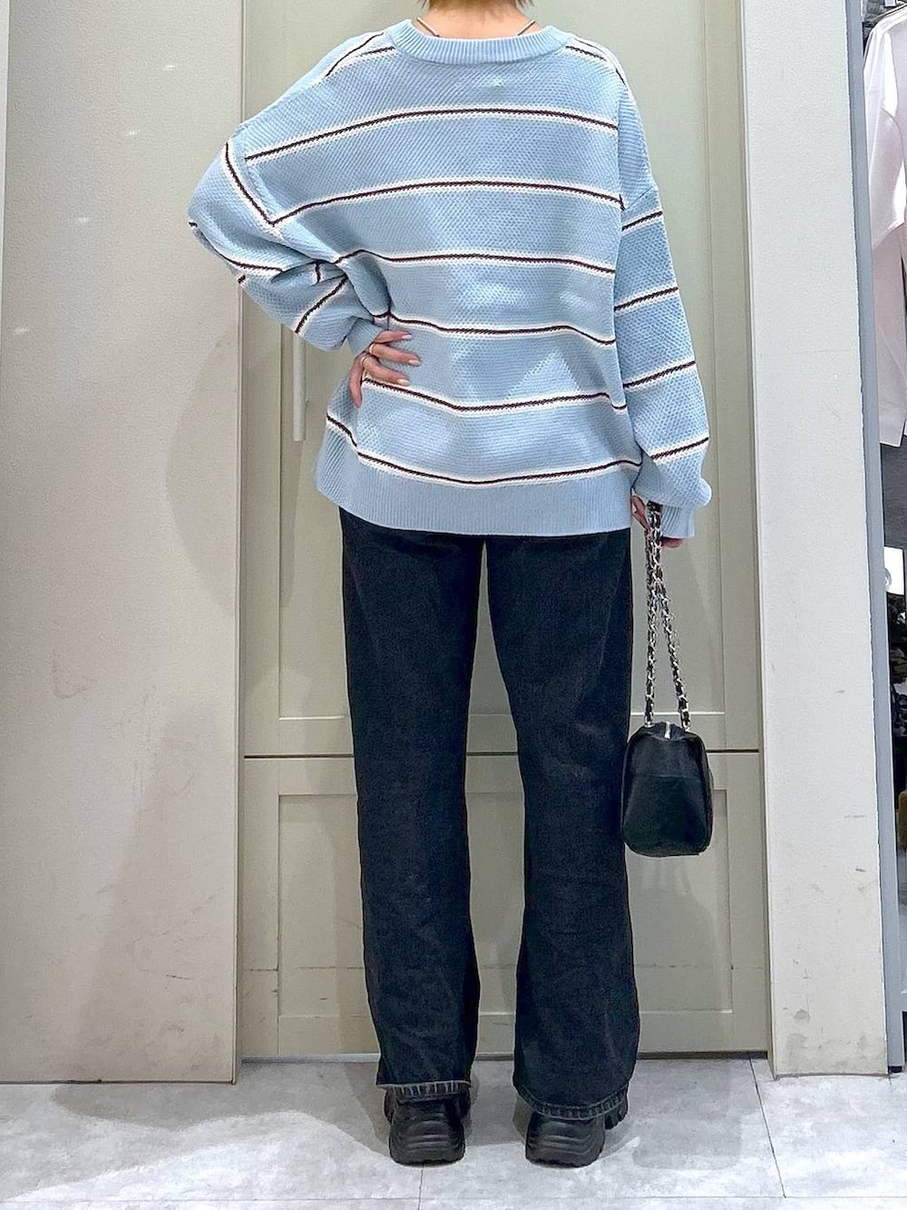 ブラック系のデニムパンツ、ブラック系のショルダーバッグ、ブラック系のローファーを着用したレディースの冬コーディネートの6枚目の写真