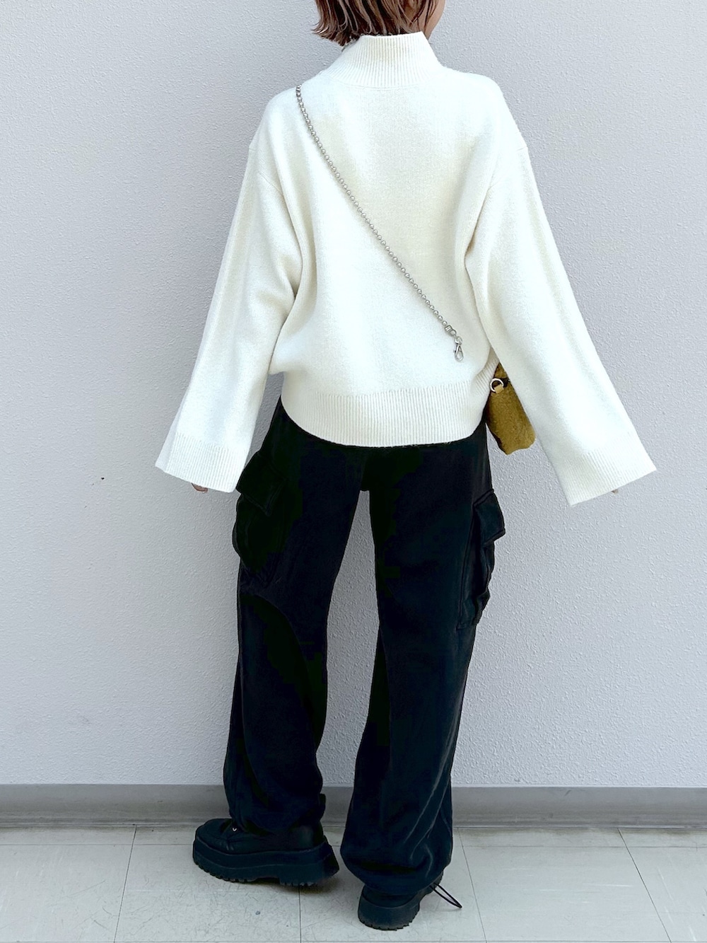 ホワイト系のニット/セーター、ブラック系のカーゴパンツ、イエロー系のショルダーバッグを着用したレディースの秋コーディネートの6枚目の写真