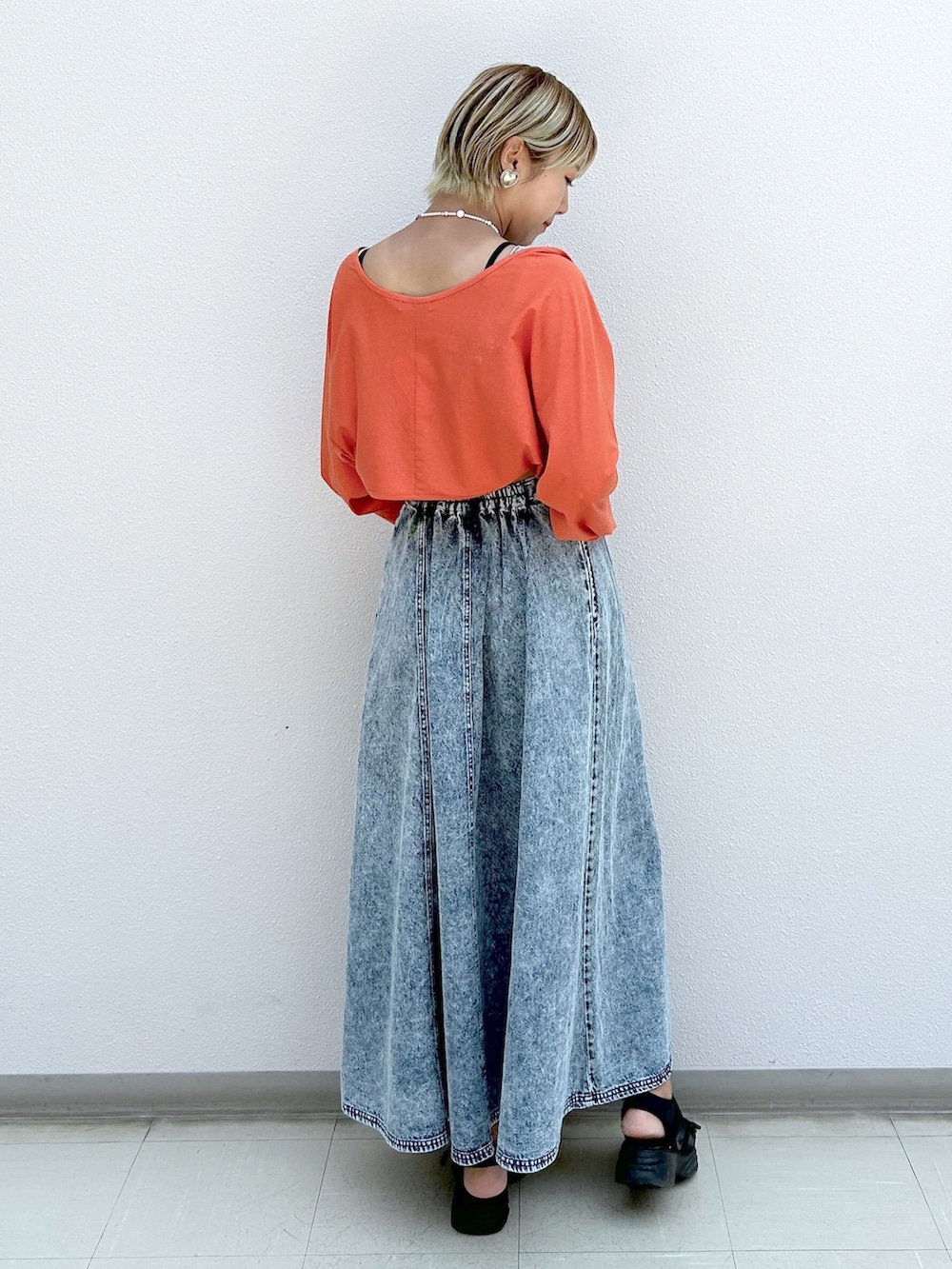 オレンジ系のカーディガン/ボレロ、ブルー系のジャンパースカートを着用したレディースの夏コーディネートの3枚目の写真