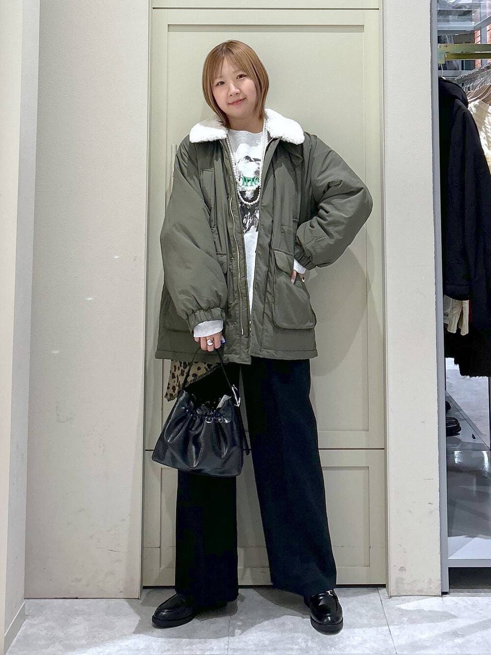 ブラック系のスラックス、グリーン系のその他アウター、ブラック系のローファーを着用したレディースの冬コーディネートの7枚目の写真