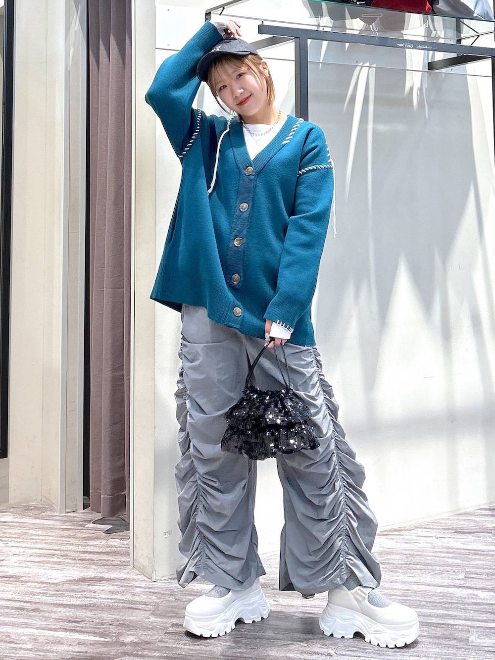 ホワイト系のニット/セーター、グレー系のその他パンツ、ブルー系のカーディガン/ボレロを着用したレディースの春コーディネートの7枚目の写真