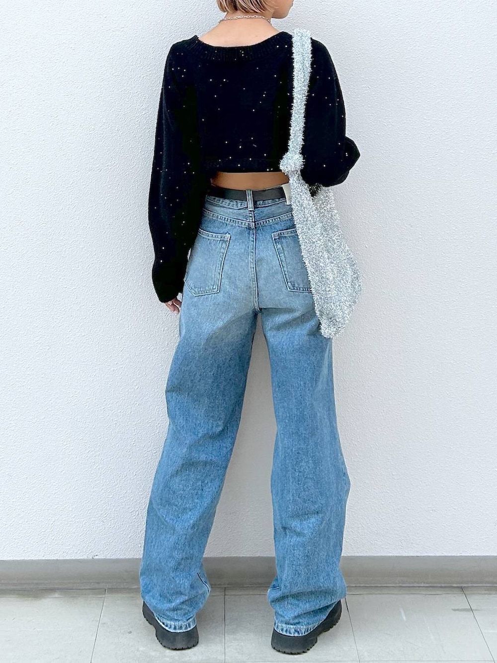 ブラック系のブーツ、ブルー系のデニムパンツ、シルバー系のトートバッグを着用したレディースの冬コーディネートの6枚目の写真