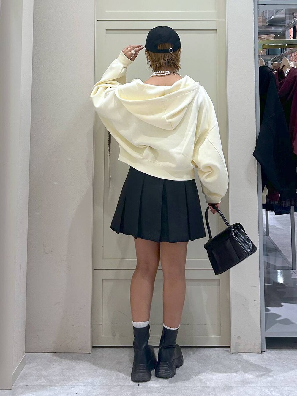 ブラック系のブーツ、ブラック系のボストンバッグ、グレー系のスカートを着用したレディースの秋コーディネートの3枚目の写真