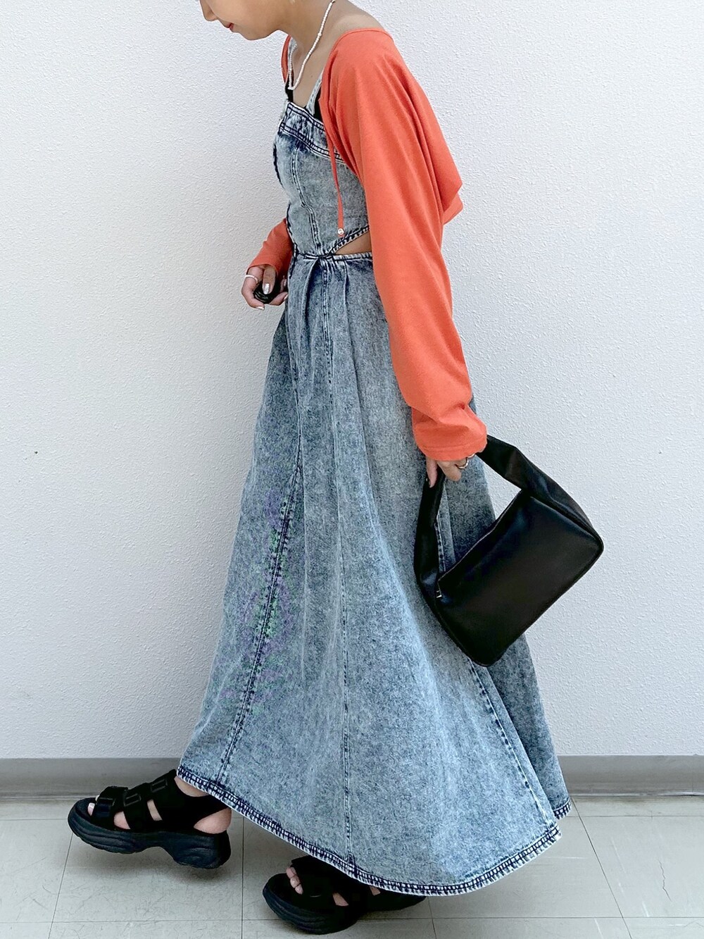 オレンジ系のカーディガン/ボレロ、ブルー系のジャンパースカートを着用したレディースの夏コーディネートの5枚目の写真