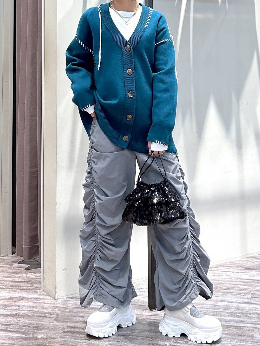ホワイト系のニット/セーター、グレー系のその他パンツ、ブルー系のカーディガン/ボレロを着用したレディースの春コーディネートの4枚目の写真