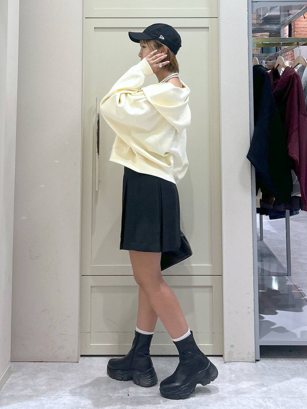 ブラック系のブーツ、ブラック系のボストンバッグ、グレー系のスカートを着用したレディースの秋コーディネートの2枚目の写真