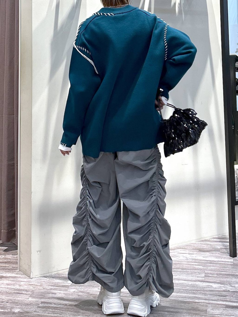 ホワイト系のニット/セーター、グレー系のその他パンツ、ブルー系のカーディガン/ボレロを着用したレディースの春コーディネートの6枚目の写真