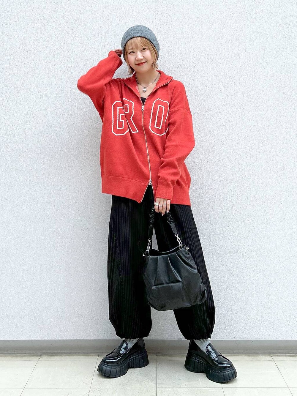 その他のその他パンツ、オレンジ系のニット/セーター、ブラック系のローファーを着用したレディースの春コーディネートの7枚目の写真