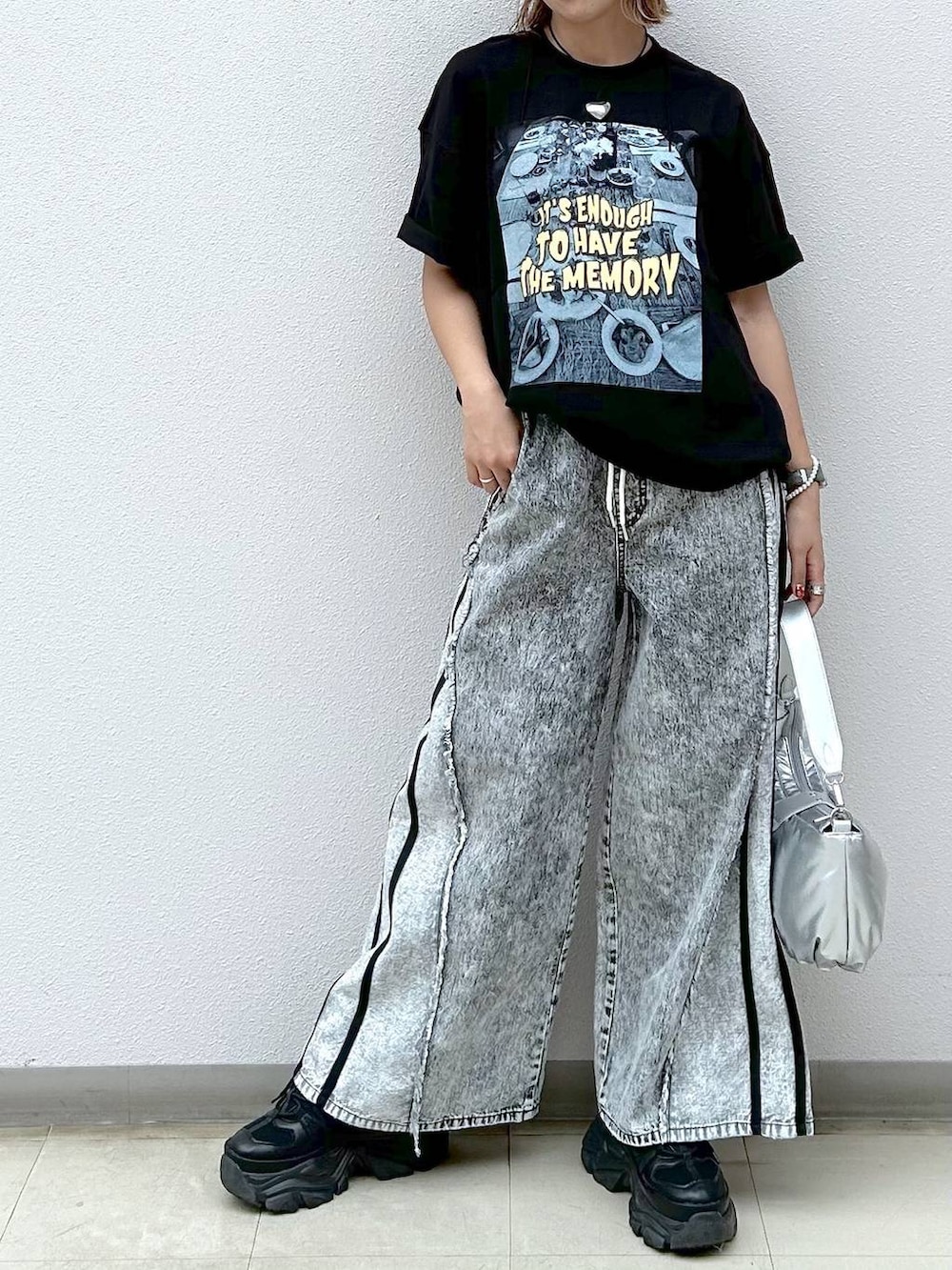 ブラック系のスニーカー、グレー系のデニムパンツ、シルバー系のショルダーバッグを着用したレディースの夏コーディネートの4枚目の写真