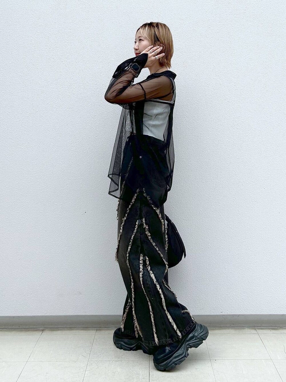 ブラック系のスニーカー、ホワイト系のタンクトップ、ブラック系のシャツ/ブラウスを着用したレディースの夏コーディネートの2枚目の写真