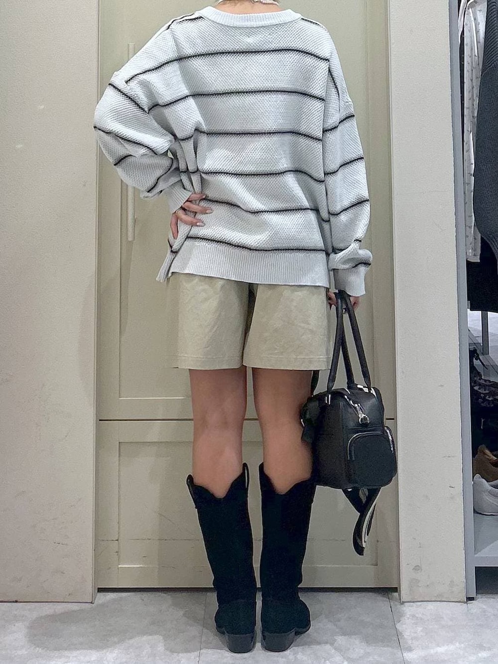 ホワイト系のキャミソール、ブラック系のブーツ、ブラック系のボストンバッグを着用したレディースの春コーディネートの5枚目の写真