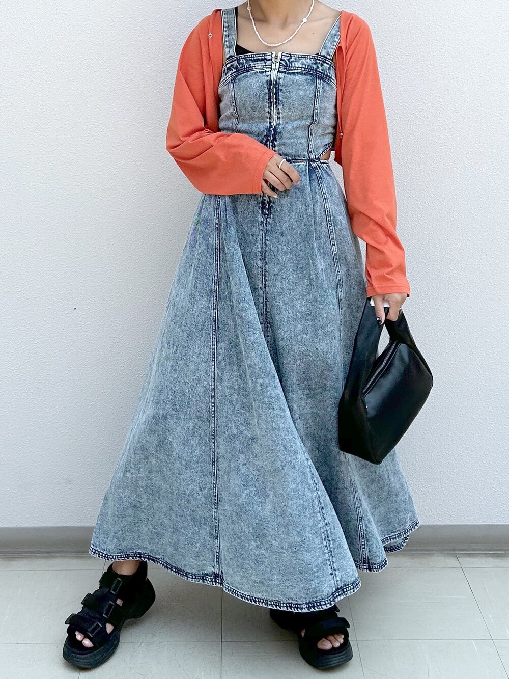 オレンジ系のカーディガン/ボレロ、ブルー系のジャンパースカートを着用したレディースの夏コーディネートの4枚目の写真