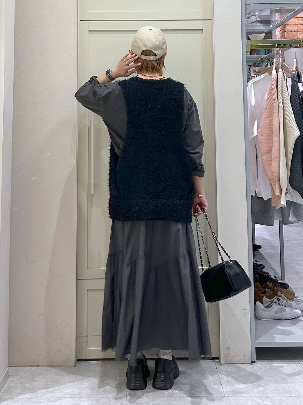 ブラック系のショルダーバッグ、ブラック系のローファー、ブラック系のベストを着用したレディースの春コーディネートの3枚目の写真