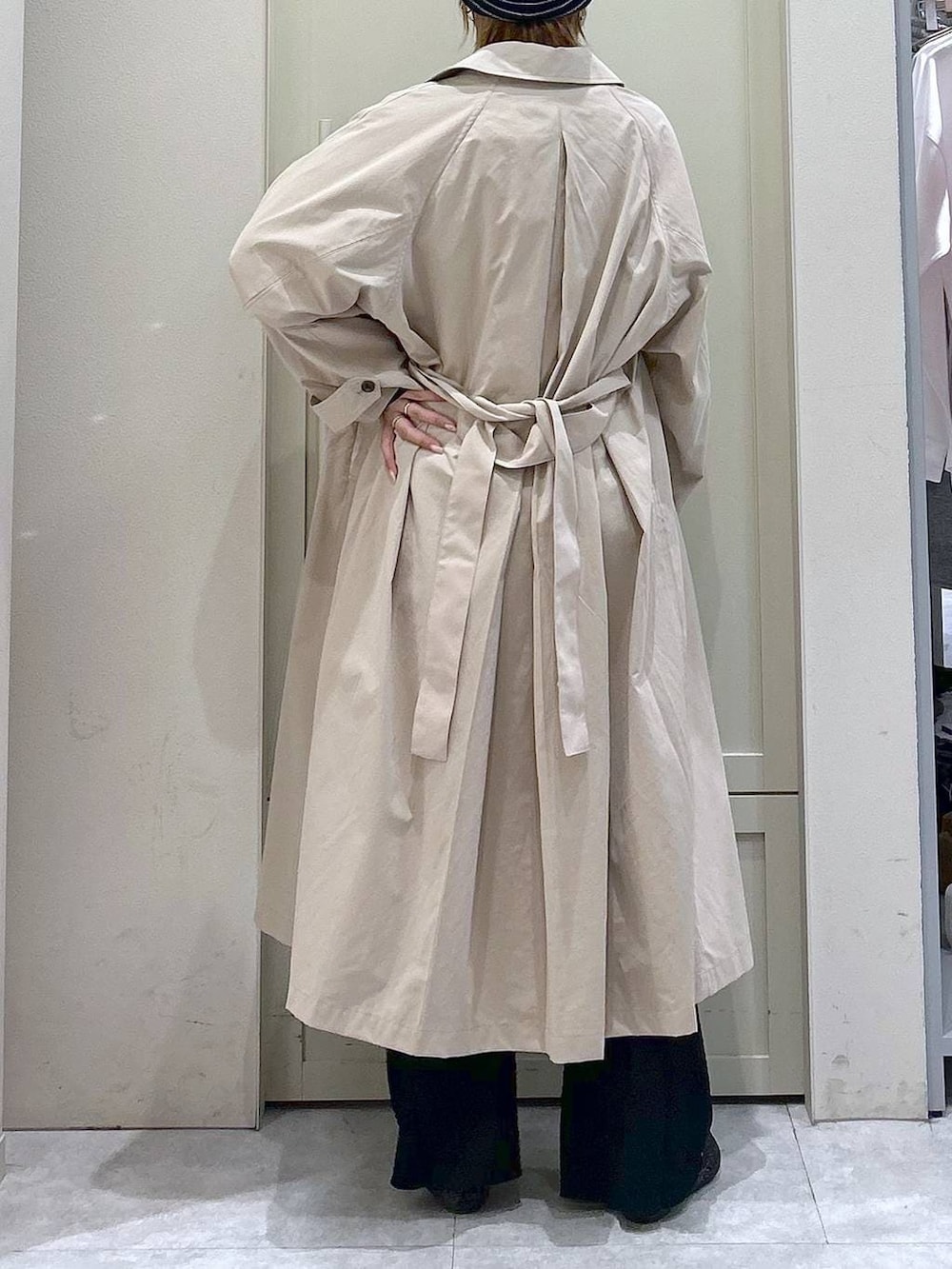 ブラック系のショルダーバッグ、ブラック系のパンプス、ベージュ系のステンカラーコートを着用したレディースの春コーディネートの6枚目の写真