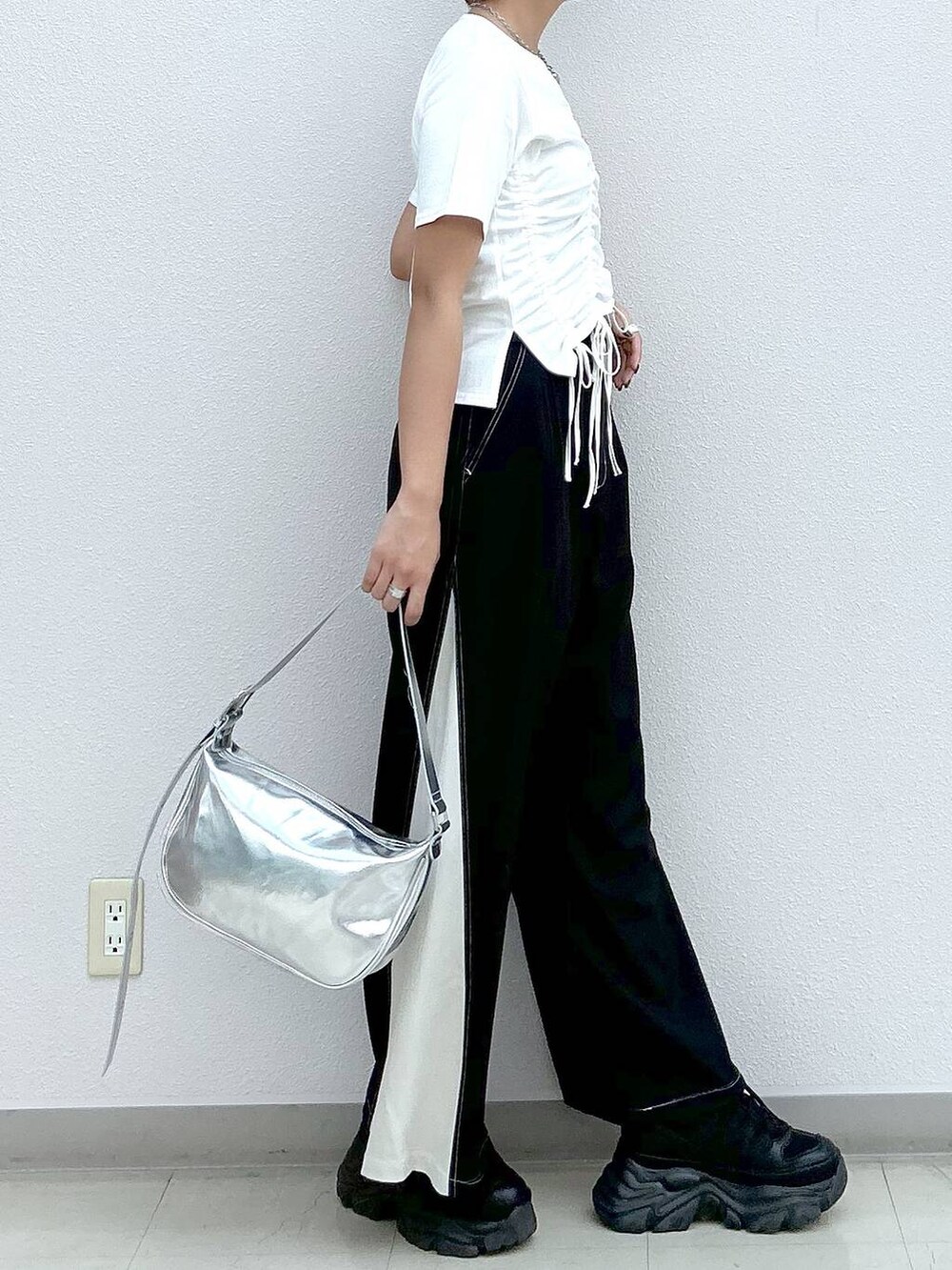 ブラック系のスニーカー、シルバー系のショルダーバッグ、ホワイト系のTシャツ/カットソーを着用したレディースの夏コーディネートの5枚目の写真