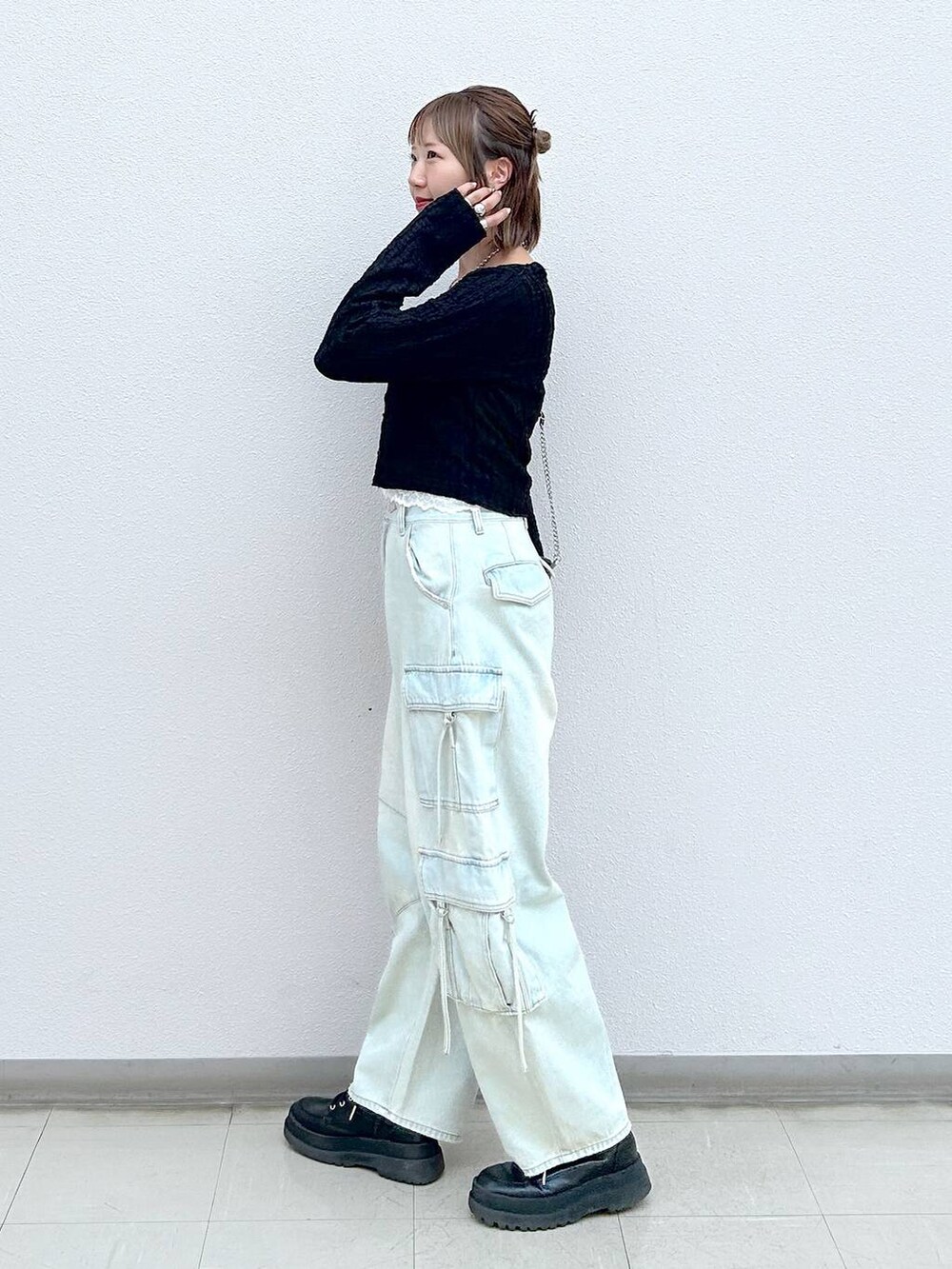 ブラック系のブーツ、ブルー系のデニムパンツ、ブラック系のショルダーバッグを着用したレディースの秋コーディネートの2枚目の写真