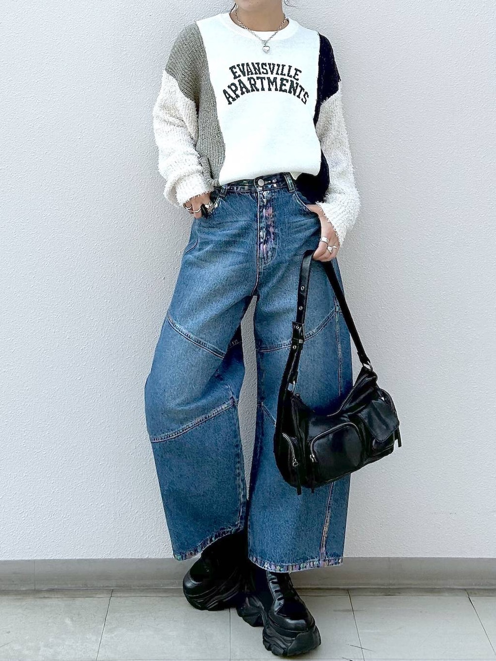 ブラック系のスニーカー、ブラック系のショルダーバッグ、ブルー系のデニムパンツを着用したレディースの冬コーディネートの4枚目の写真