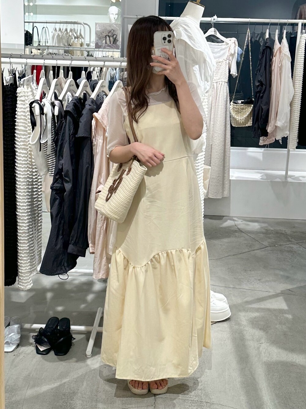 ブラウン系のトートバッグ、イエロー系のワンピース、ゴールド系のシューズを着用したレディースの春コーディネートの3枚目の写真