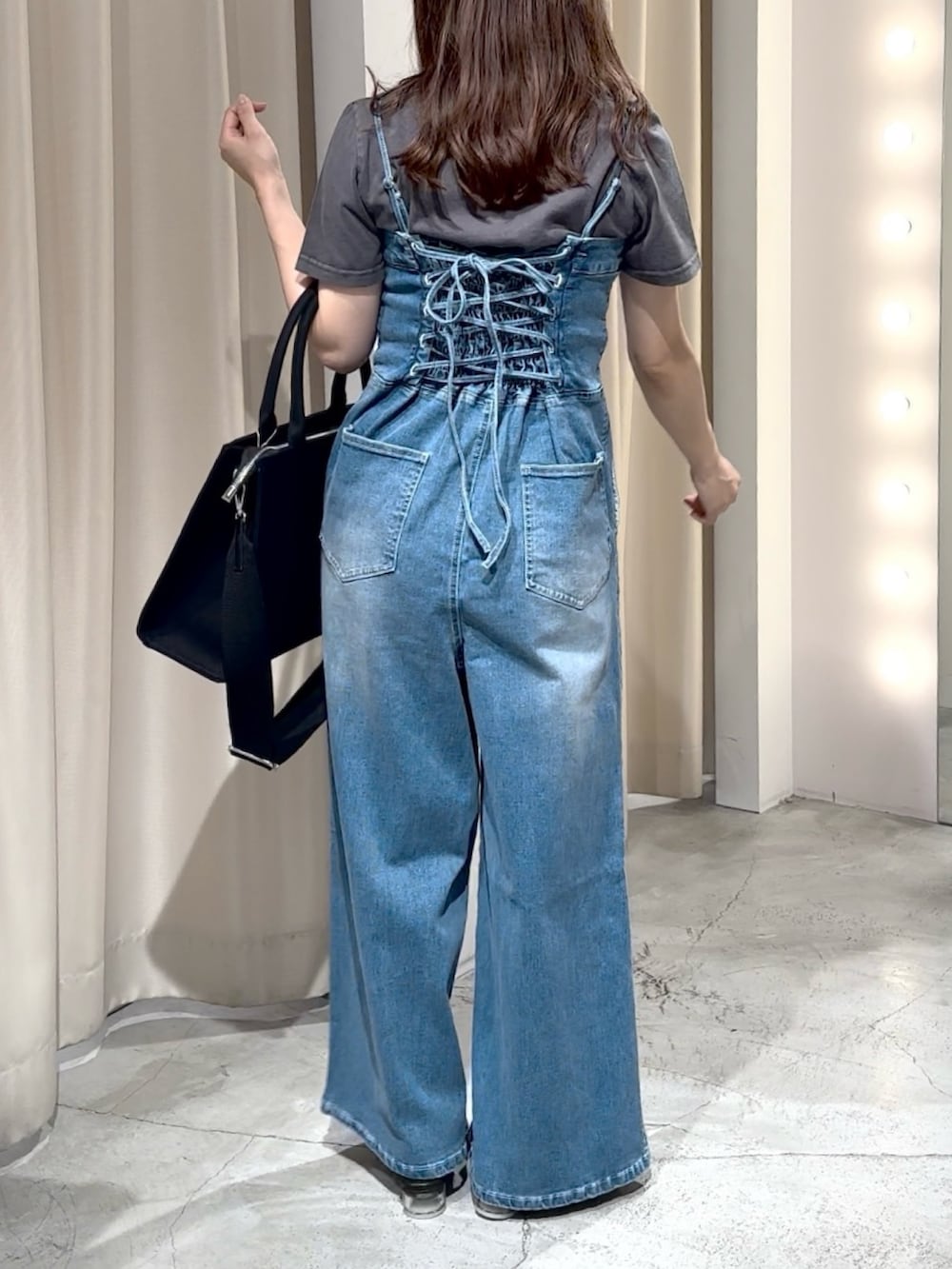 ブルー系のサロペット/オーバーオール、ブラック系のTシャツ/カットソー、ブラック系のサンダルを着用したレディースの夏コーディネートの7枚目の写真