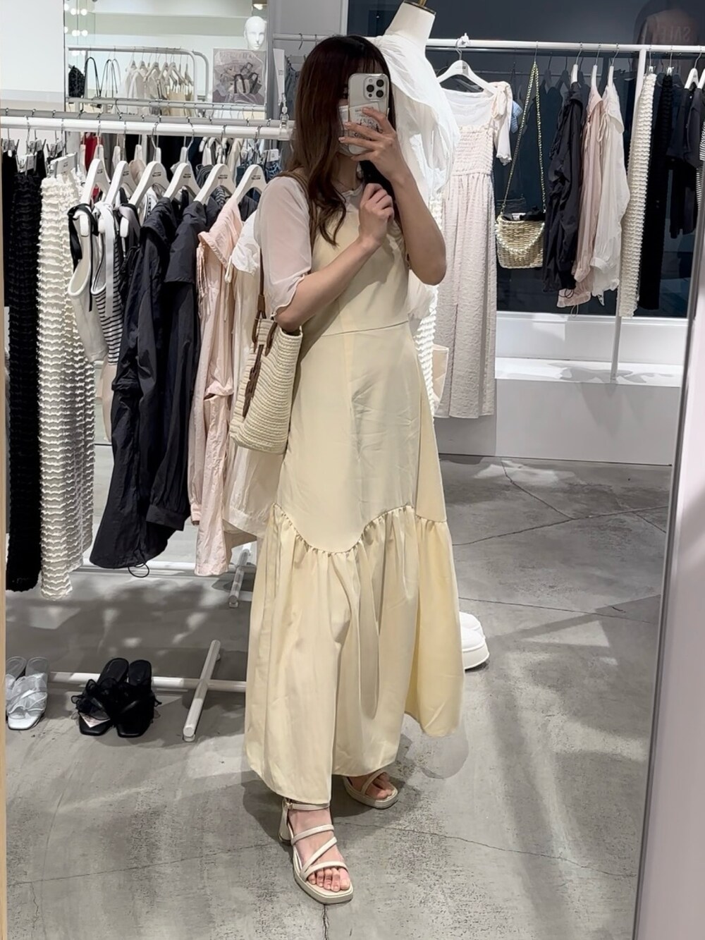 ブラウン系のトートバッグ、イエロー系のワンピース、ゴールド系のシューズを着用したレディースの春コーディネートの2枚目の写真