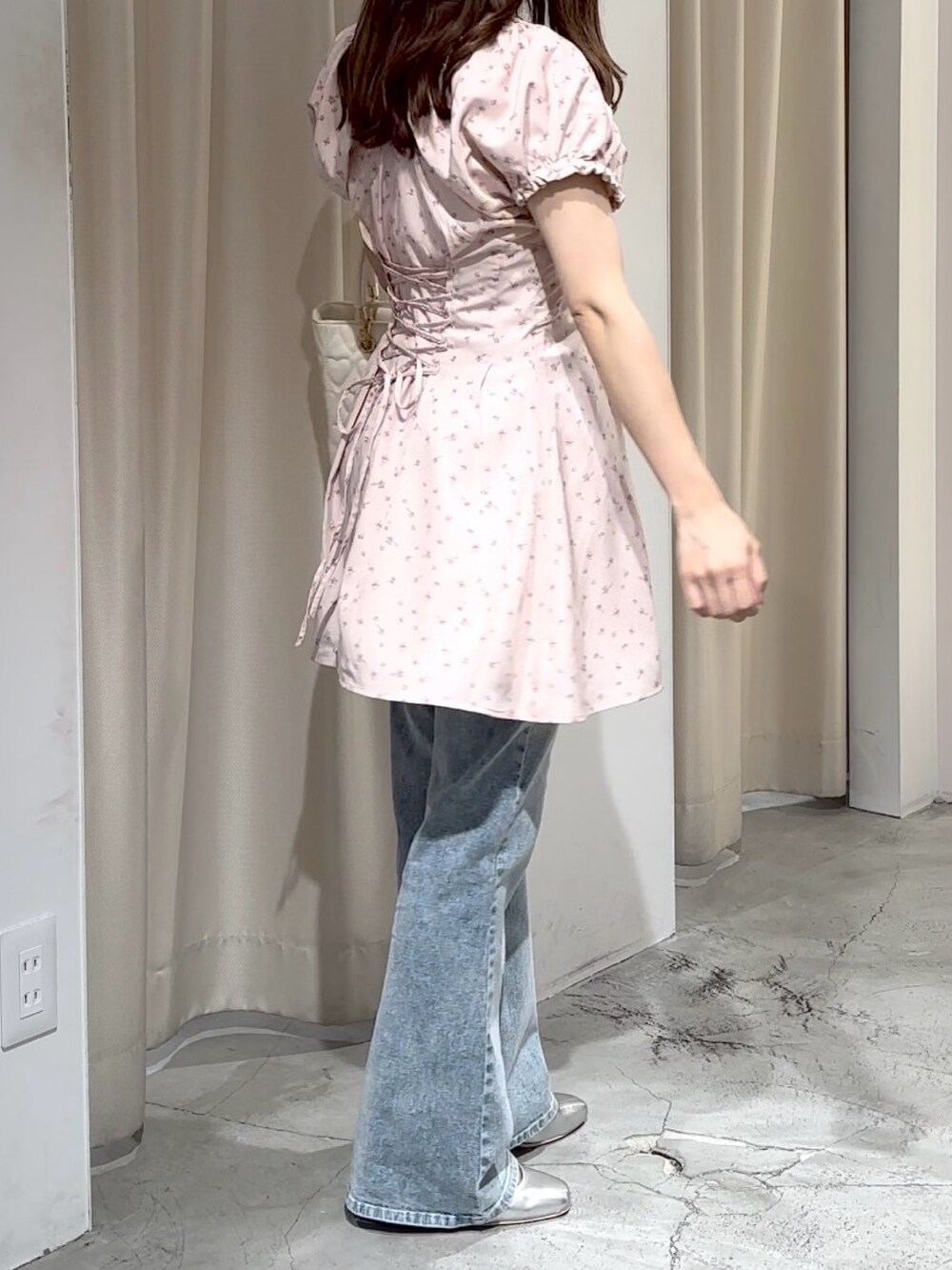 ピンク系のワンピース、ブルー系のデニムパンツ、シルバー系のパンプスを着用したレディースの夏コーディネートの4枚目の写真