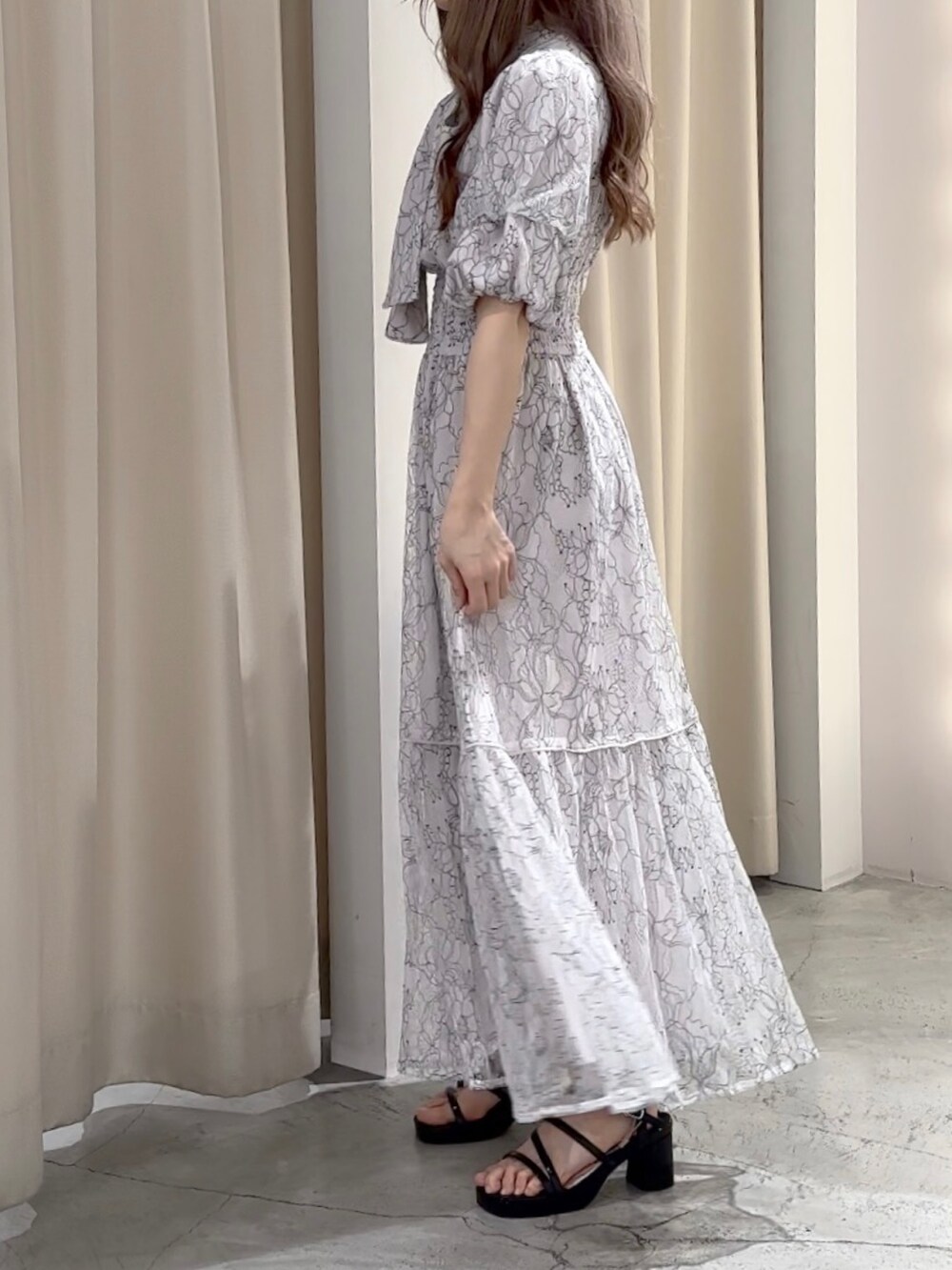 ホワイト系のワンピース/ドレス、ブラック系のサンダルを着用したレディースの春コーディネートの2枚目の写真