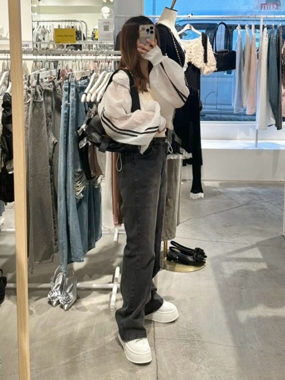 ホワイト系のブルゾン、ホワイト系のキャミソール、グレー系のデニムパンツを着用したレディースの夏コーディネートの7枚目の写真