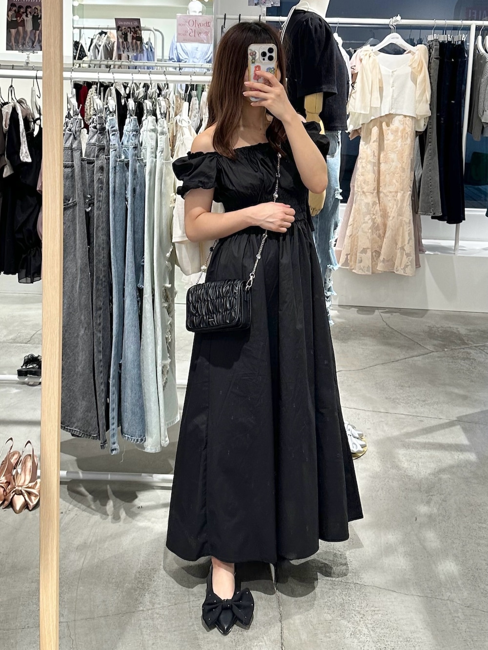 ブラック系のワンピース、ブラック系のパンプス、ブラック系のショルダーバッグを着用したレディースの夏コーディネートの3枚目の写真