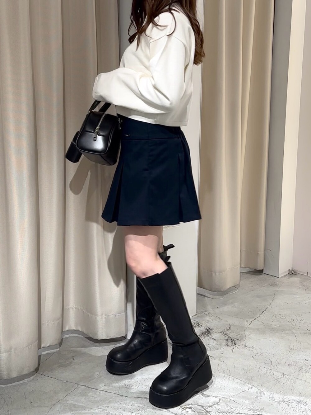 ブルー系のスカート、ブルー系のテーラードジャケット、ホワイト系のニット/セーターを着用したレディースの冬コーディネートの9枚目の写真