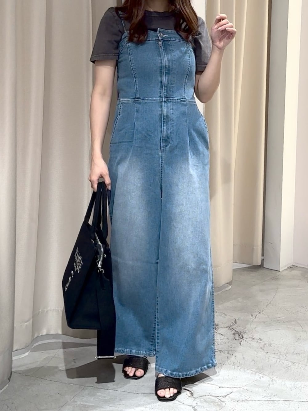 ブルー系のサロペット/オーバーオール、ブラック系のTシャツ/カットソー、ブラック系のサンダルを着用したレディースの夏コーディネートの2枚目の写真