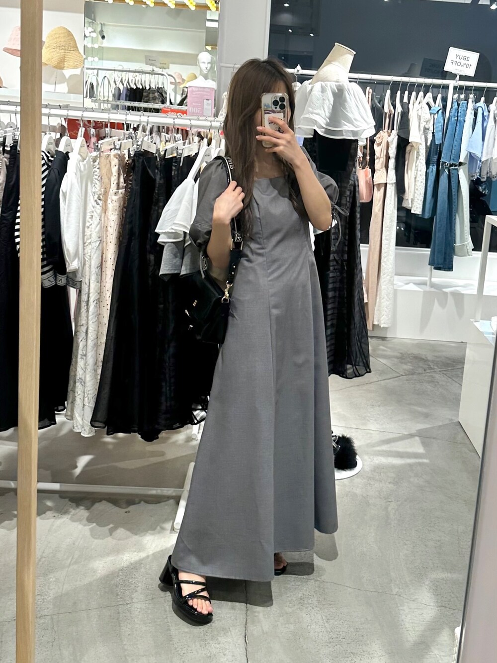 ブラック系のショルダーバッグ、グレー系のワンピースを着用したレディースの夏コーディネートの4枚目の写真