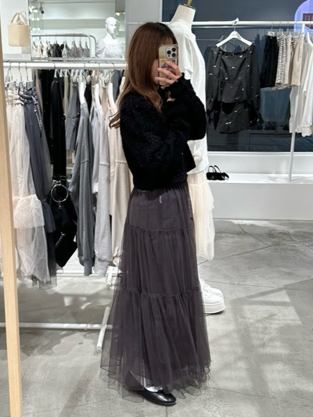 ブラック系のカーディガン/ボレロ、グレー系のスカートを着用したレディースの春コーディネートの3枚目の写真