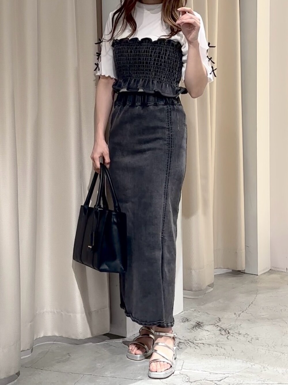 ブラック系のデニムスカート、ホワイト系のTシャツ/カットソー、シルバー系のサンダルを着用したレディースの夏コーディネートの4枚目の写真