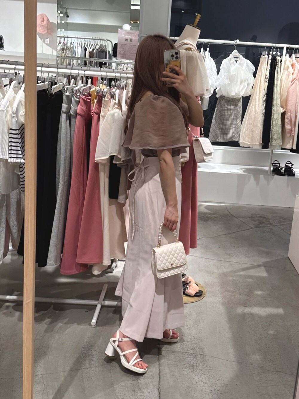 ブラウン系のTシャツ/カットソー、ホワイト系のスカート、ホワイト系のサンダルを着用したレディースの春コーディネートの3枚目の写真