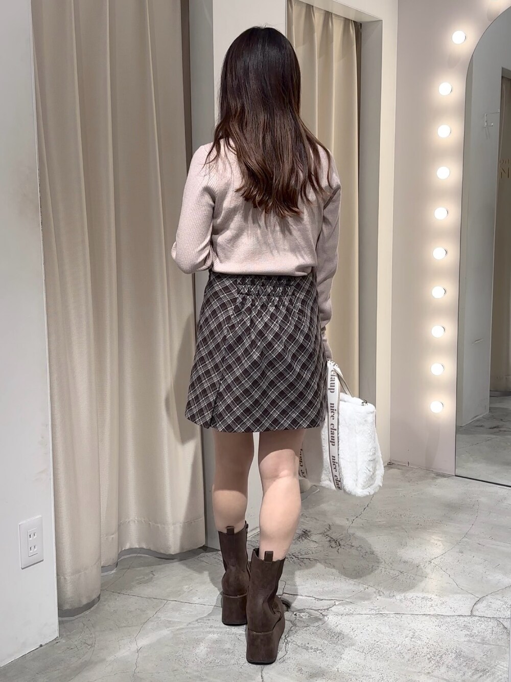 ホワイト系のダウンジャケット/コート、ブラウン系のスカート、ベージュ系のニット/セーターを着用したレディースの冬コーディネートの8枚目の写真