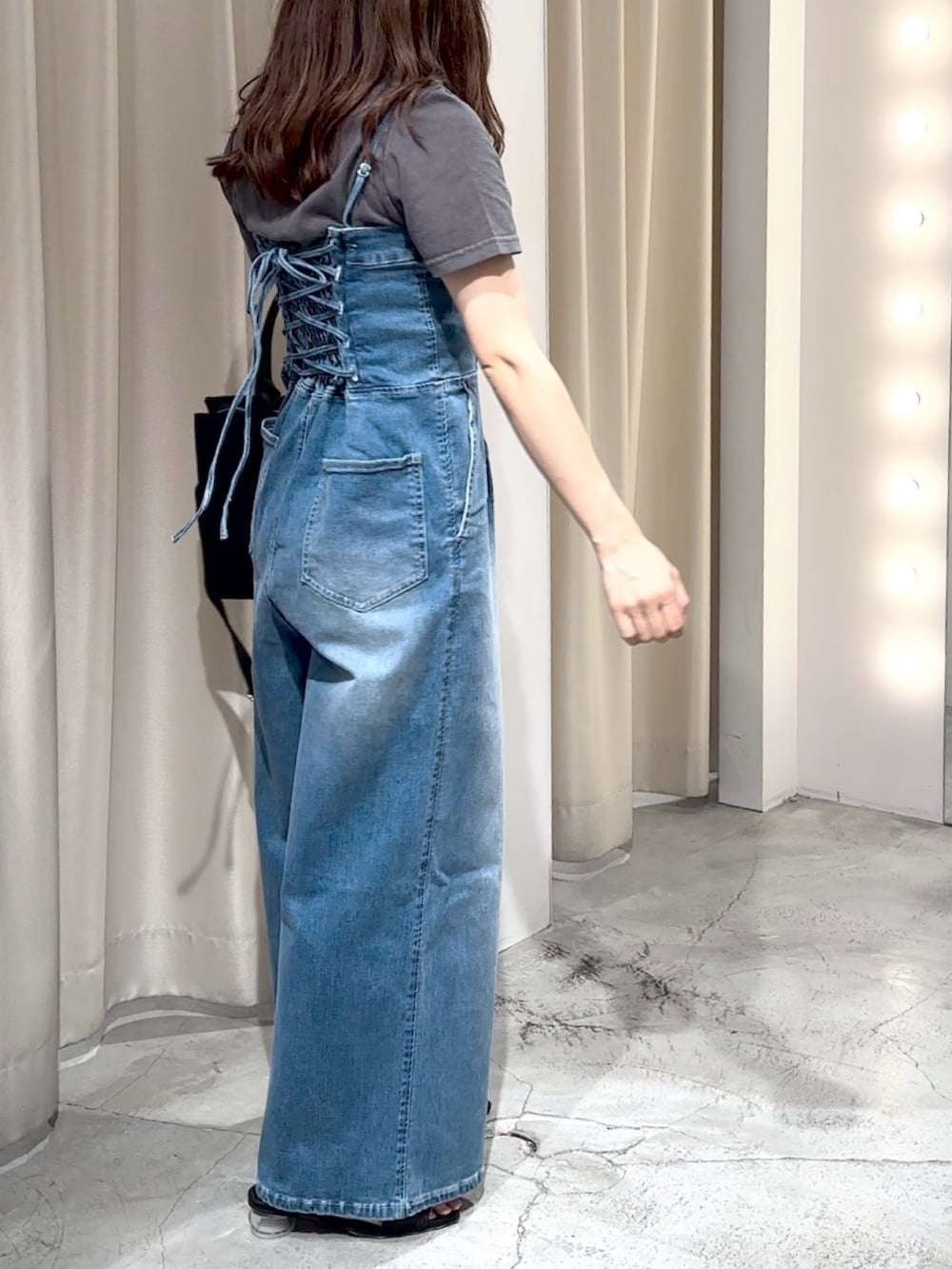 ブルー系のサロペット/オーバーオール、ブラック系のTシャツ/カットソー、ブラック系のサンダルを着用したレディースの夏コーディネートの6枚目の写真