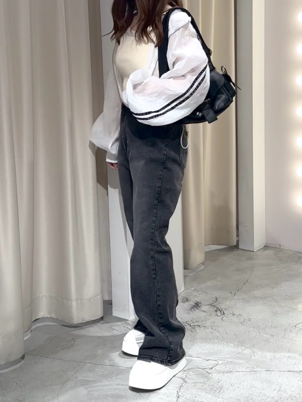 ホワイト系のブルゾン、ホワイト系のキャミソール、グレー系のデニムパンツを着用したレディースの夏コーディネートの6枚目の写真