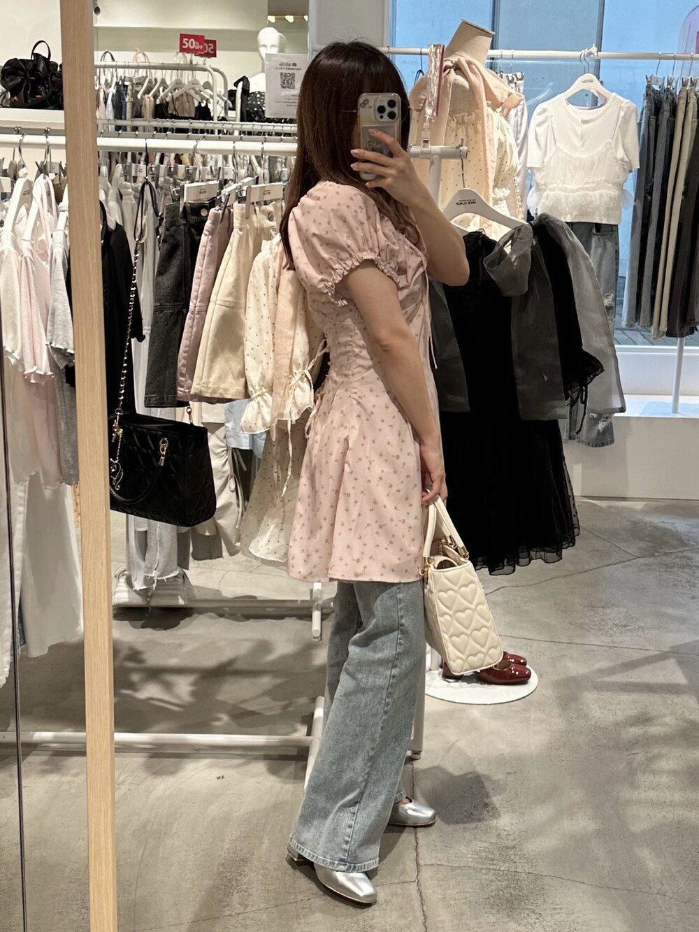 ピンク系のワンピース、ブルー系のデニムパンツ、シルバー系のパンプスを着用したレディースの夏コーディネートの7枚目の写真