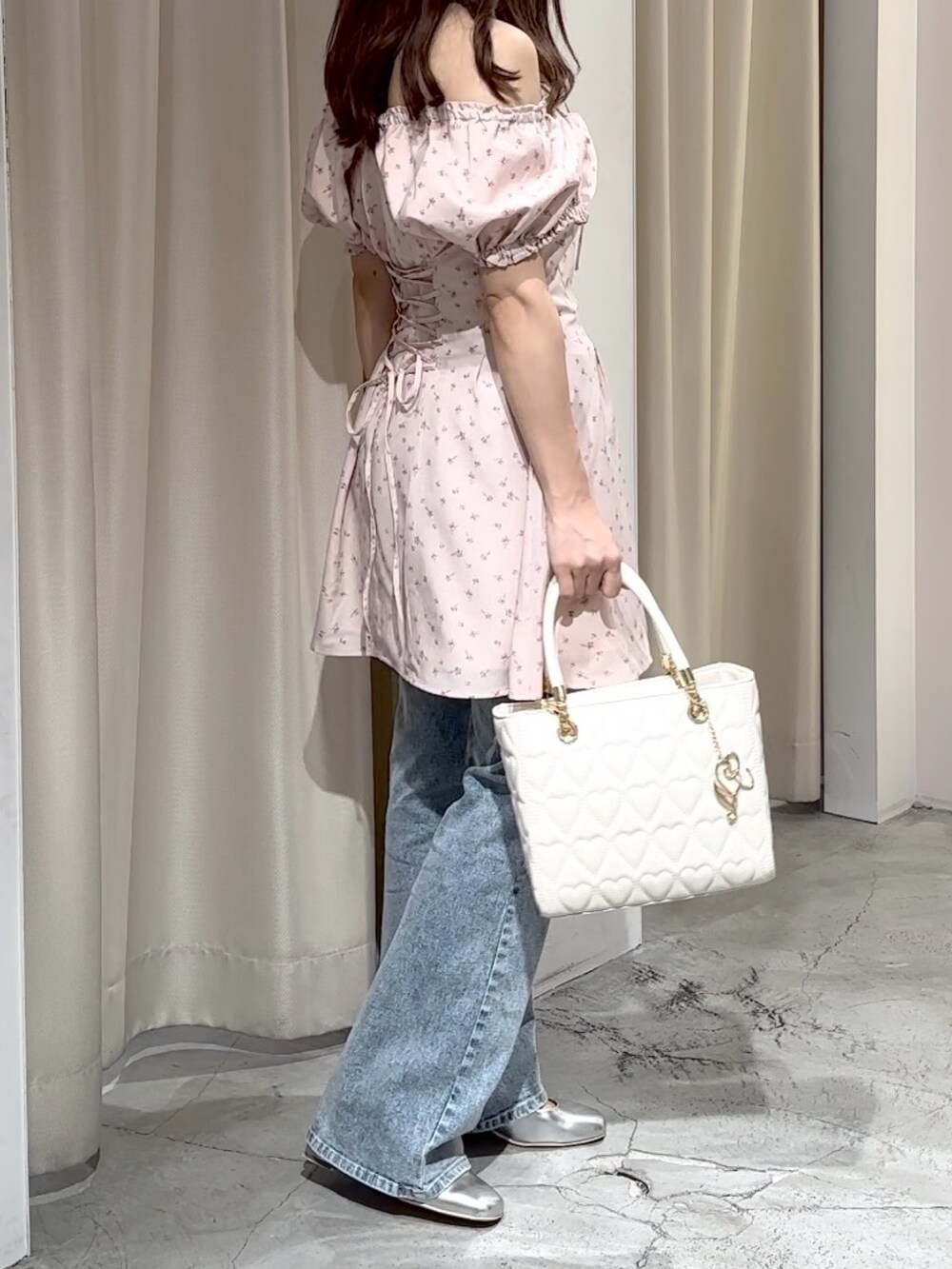 ピンク系のワンピース、ブルー系のデニムパンツ、シルバー系のパンプスを着用したレディースの夏コーディネートの9枚目の写真