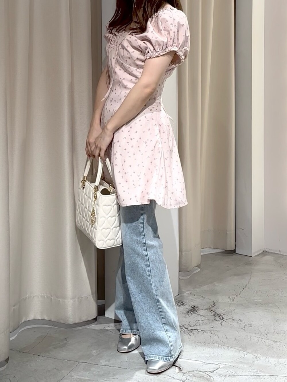 ピンク系のワンピース、ブルー系のデニムパンツ、シルバー系のパンプスを着用したレディースの夏コーディネートの3枚目の写真