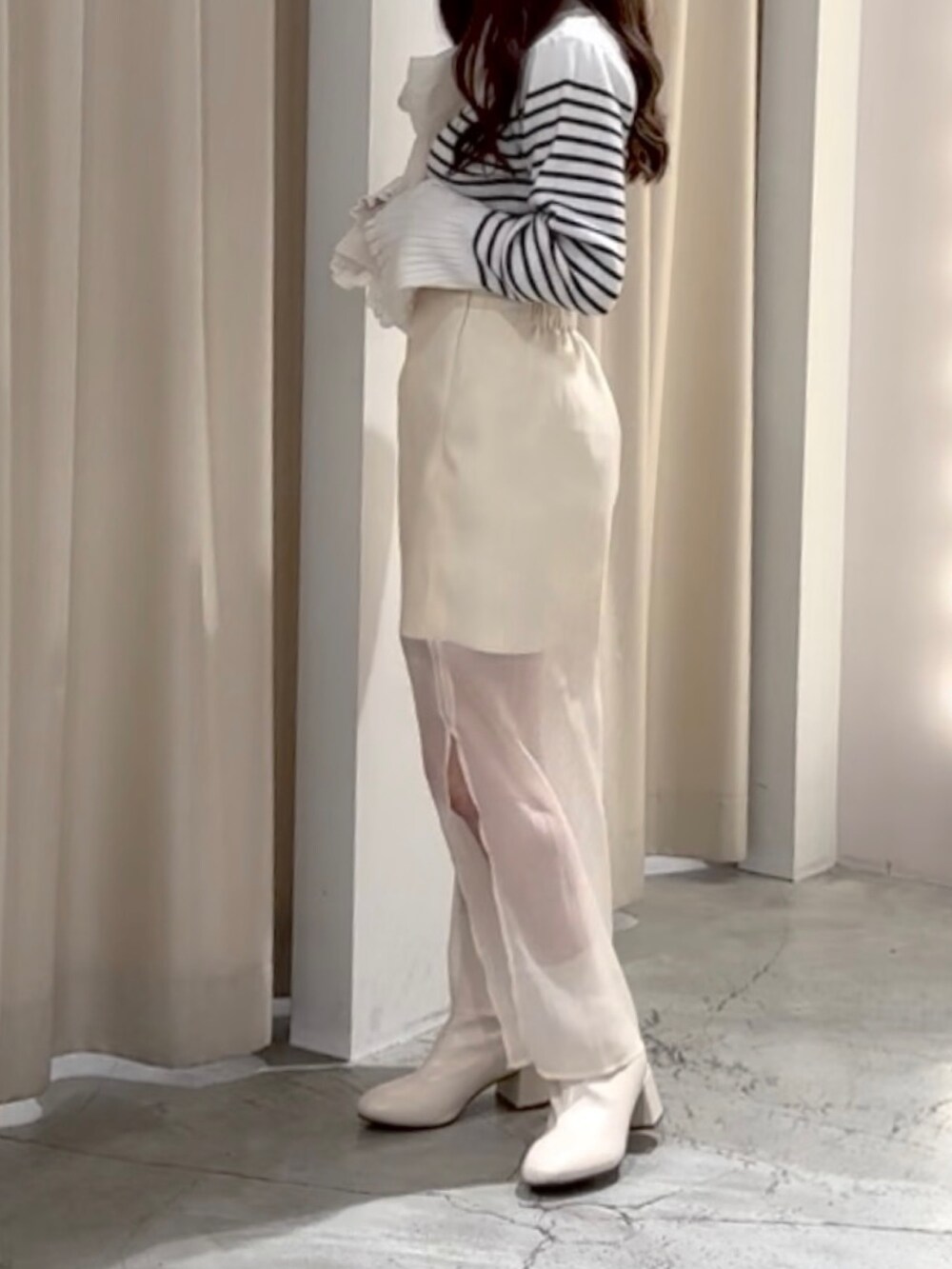 ブラック系のニット/セーター、ホワイト系のスカートを着用したレディースの冬コーディネートの3枚目の写真