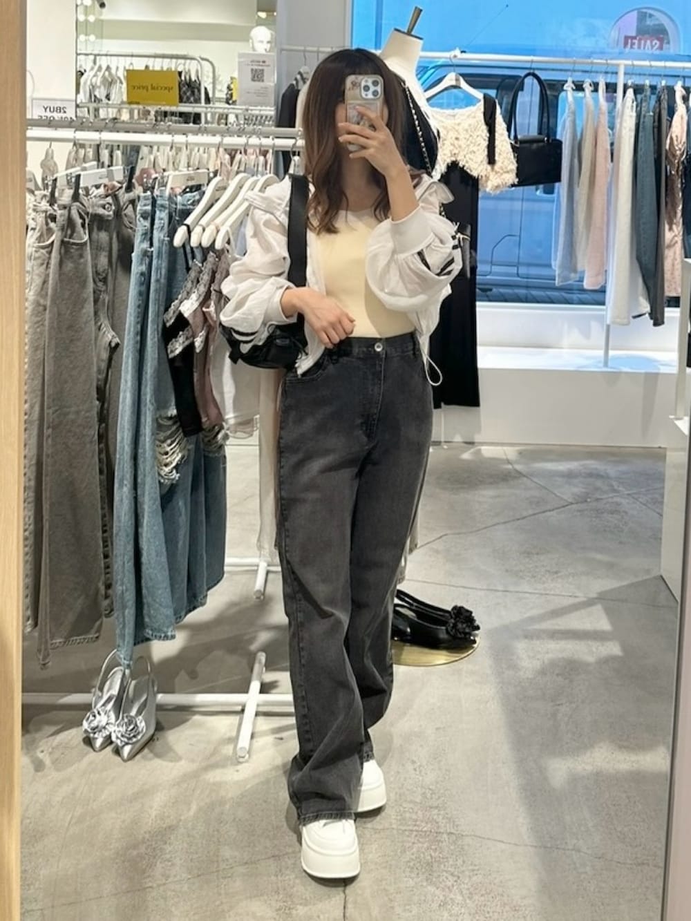 ホワイト系のブルゾン、ホワイト系のキャミソール、グレー系のデニムパンツを着用したレディースの夏コーディネートの2枚目の写真