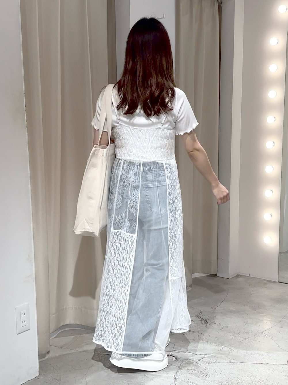 ホワイト系のワンピース、ブルー系のデニムパンツ、ホワイト系のトートバッグを着用したレディースの夏コーディネートの7枚目の写真