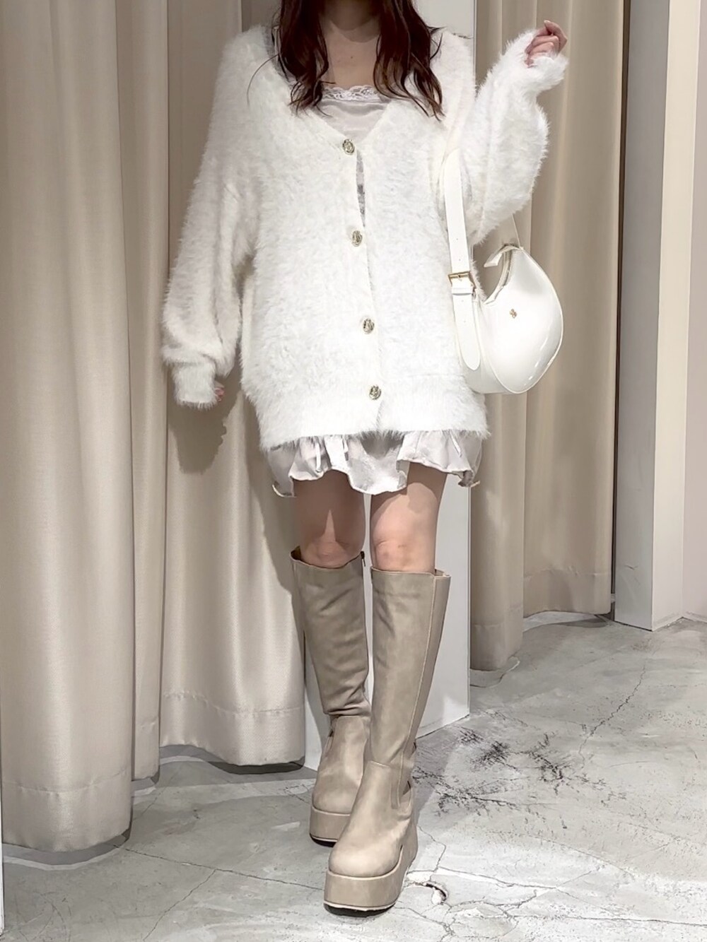 ホワイト系のカーディガン/ボレロ、ベージュ系のブーツ、ホワイト系のショルダーバッグを着用したレディースの秋コーディネートの5枚目の写真